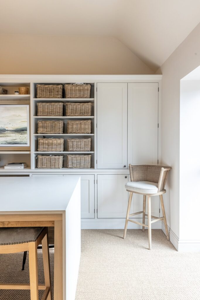 Light-filled interior design studio in Aldbury featuring wicker baskets and organized shelving.
