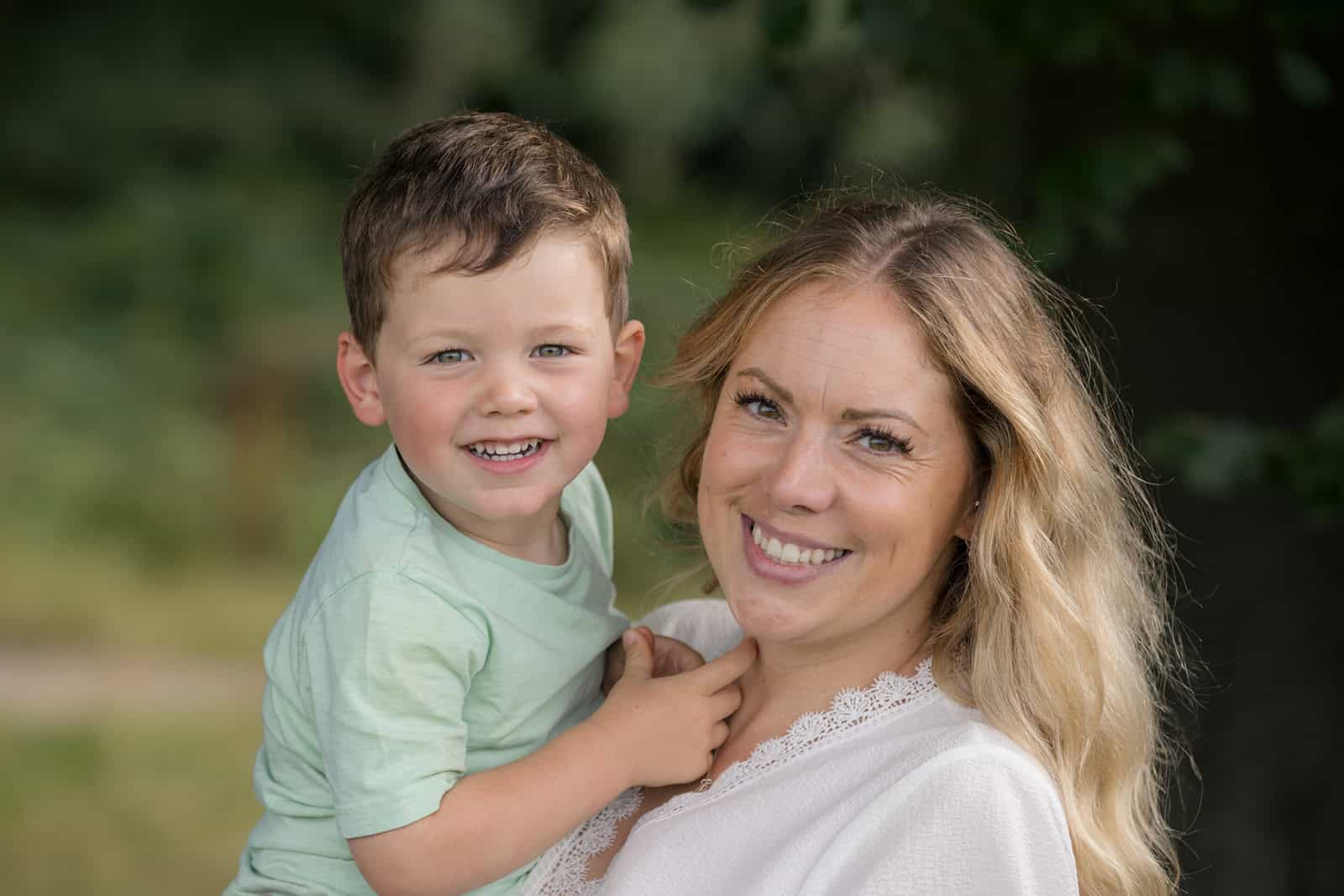 A mum and her son smile at the camera