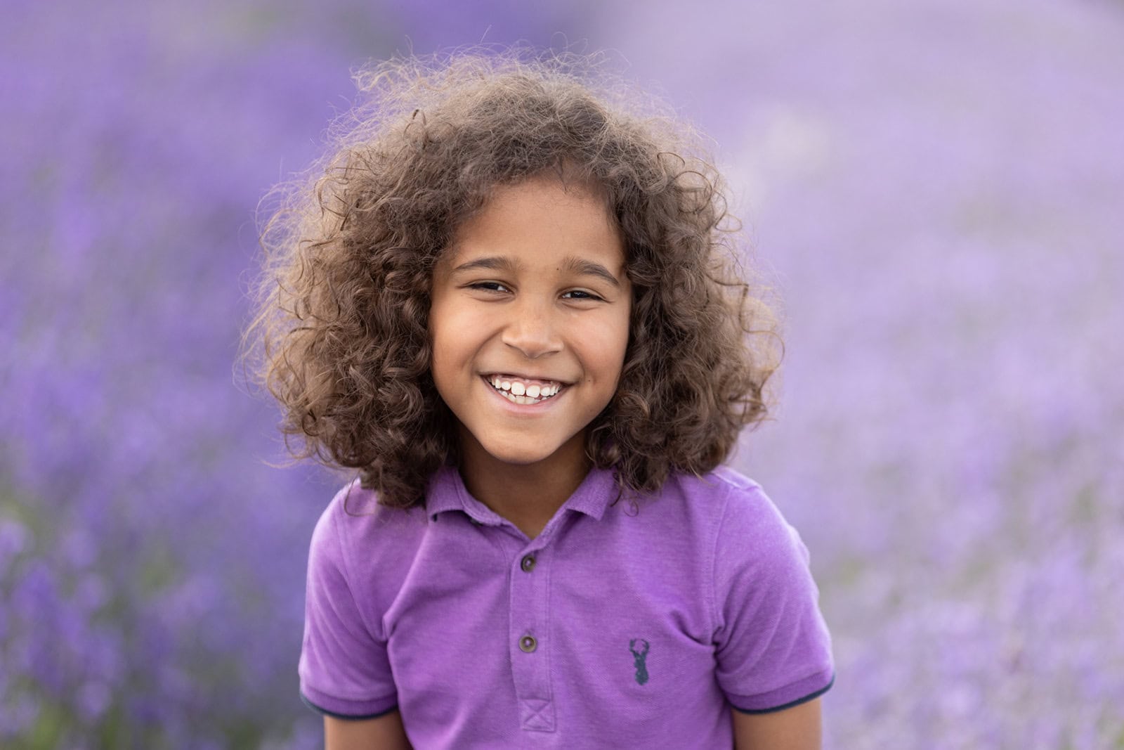 A boy smiles at the camera during a photoshoot at Hitchin Lavender fields