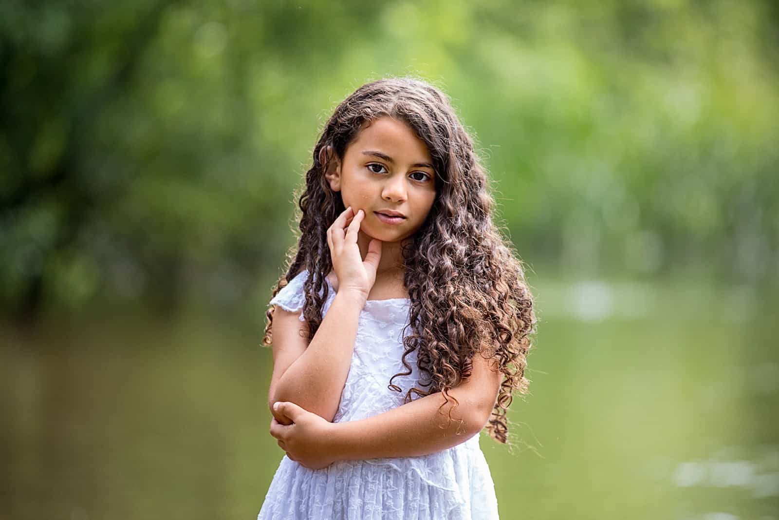 A girl, age about 10, smiles at the camera during a photoshoot in a park in North London