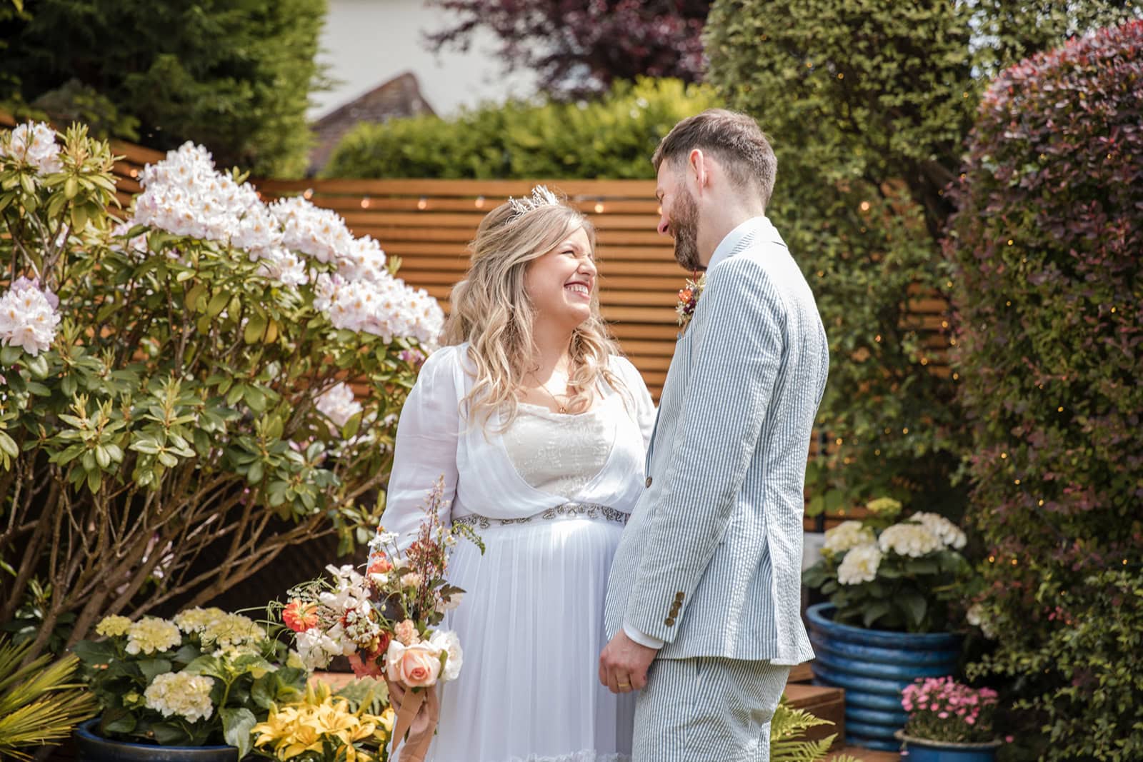 A wider shot of a bride and groom relaxing in the garden on their wedding day in Berkhamsted