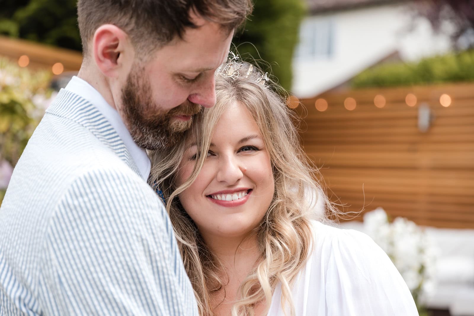 A bride rests her head on her grooms chest as they enjoy a quiet moment on their wedding day