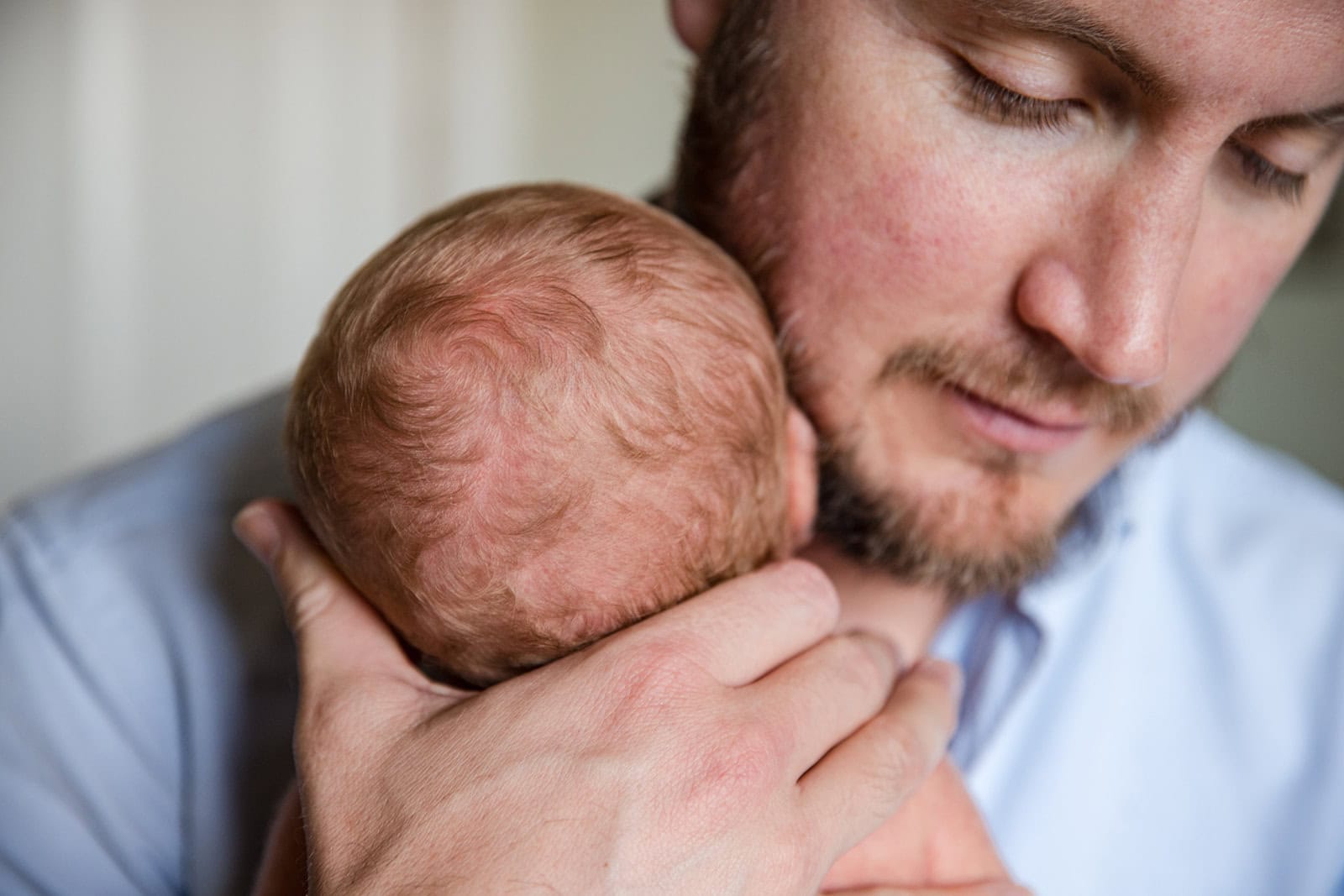 Dad cuddles his nweborn during a photoshoot in Tring