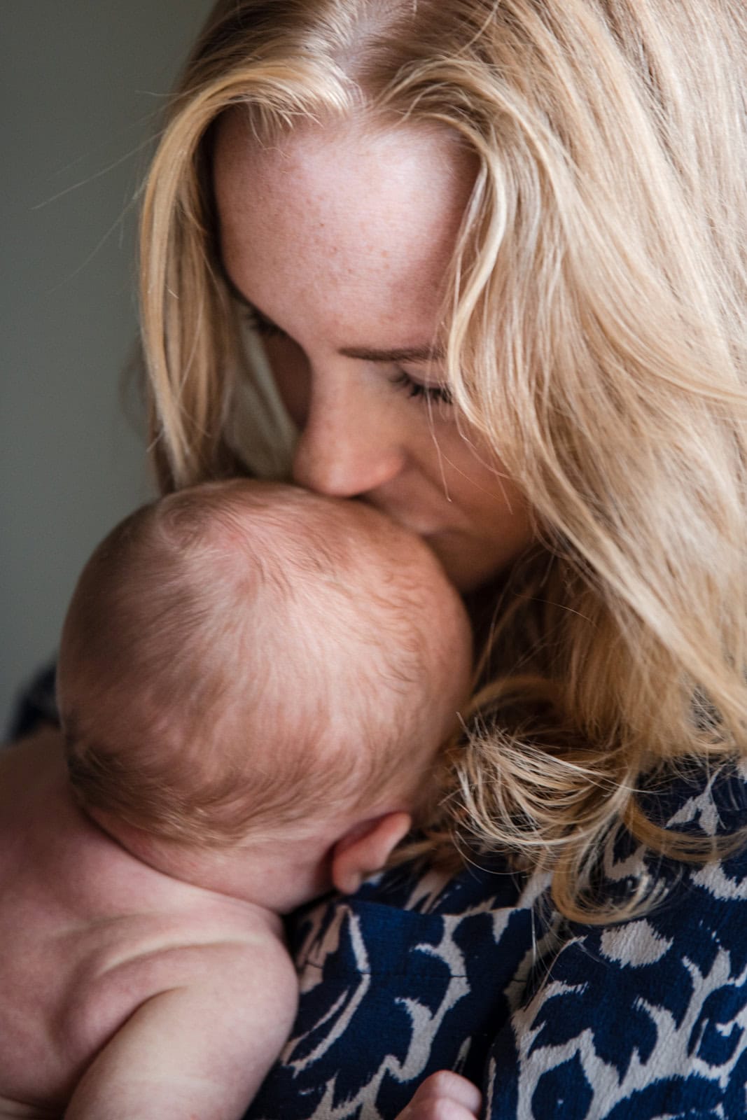 New mum kisses the top of her baby's head