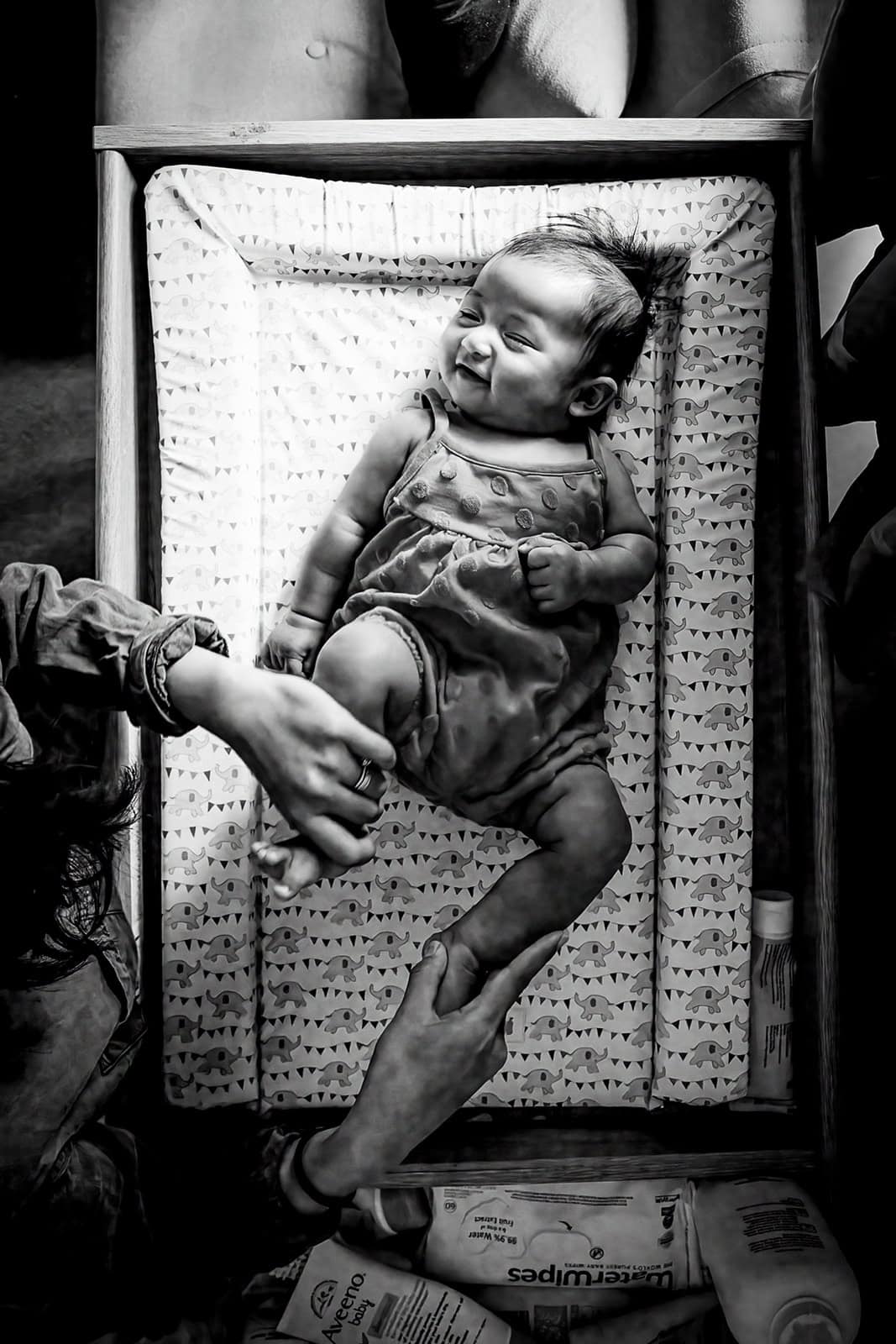 Black and white image of a baby on a changing mat during a photoshoot in Berkhamsted
