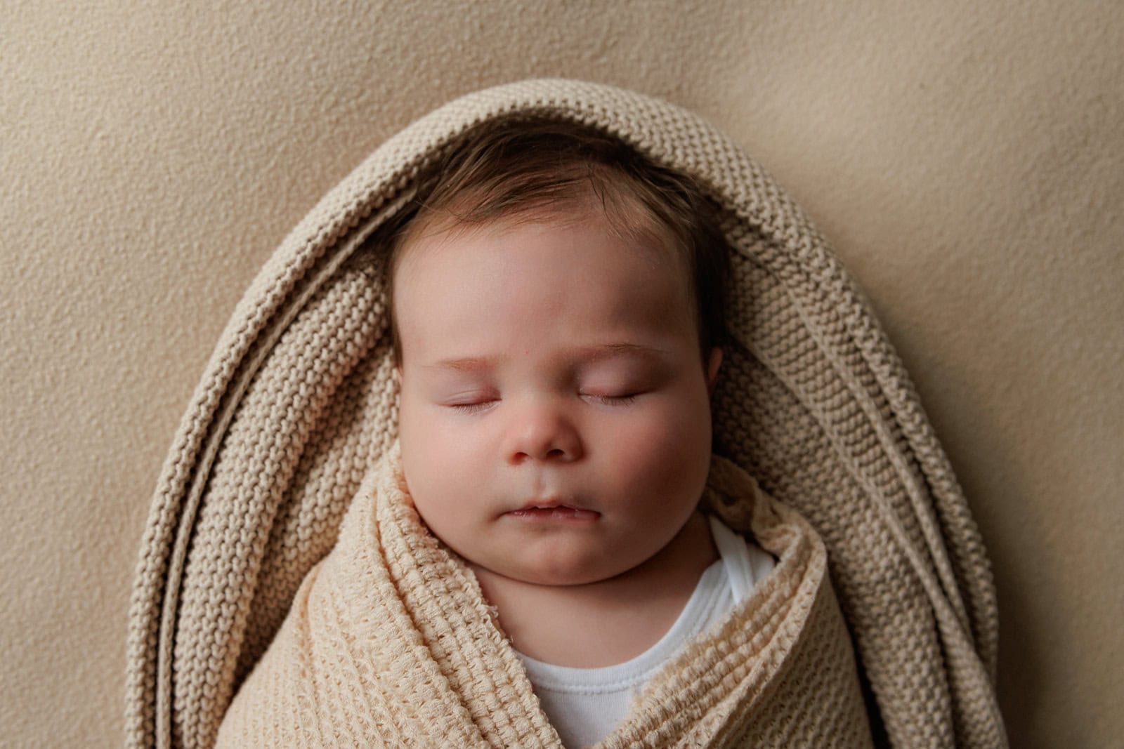 Baby sleeps while wrapped in blankets