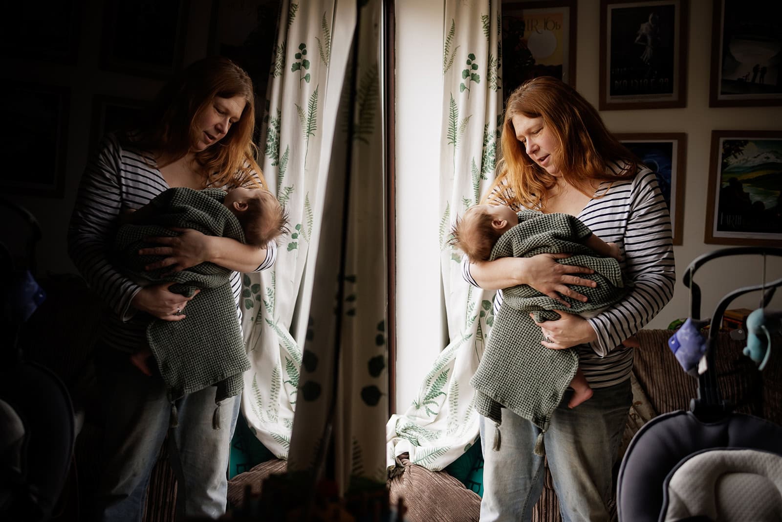 A mum cradles her new baby by the window