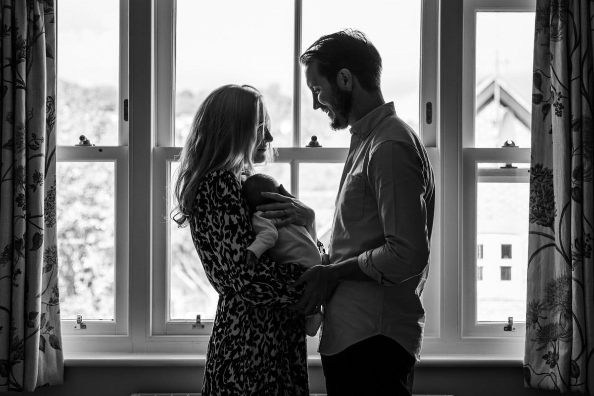 Black and white silhouette of a baby and new parents