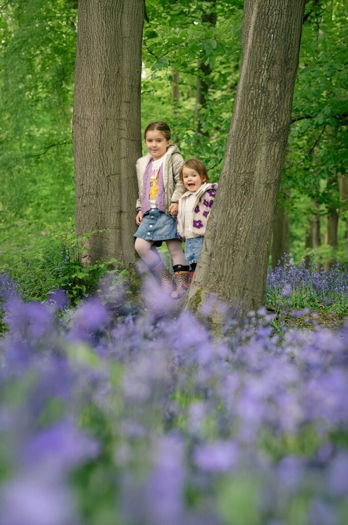 Two children stand surrounded by a carpet of bluebells in the Ashridge Estate, Hertfordshire