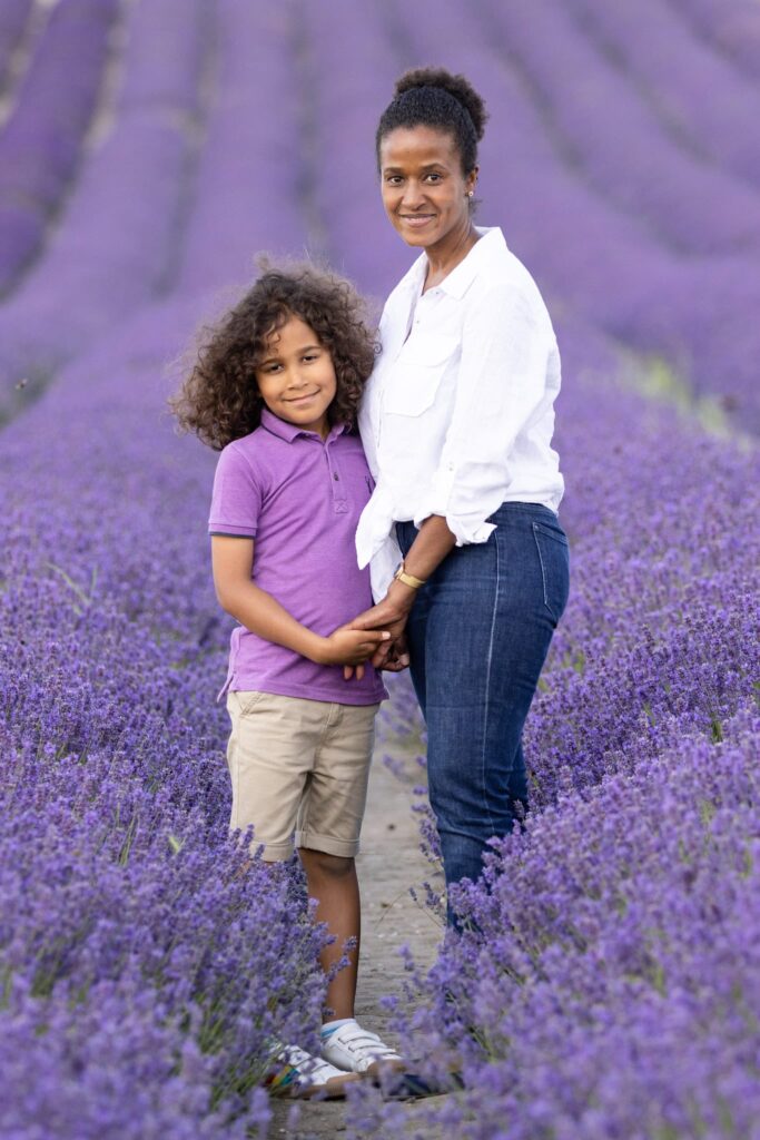 A mother and son face each other, with their heads turned to the camera during an evening photoshoot at Hitchin lavender